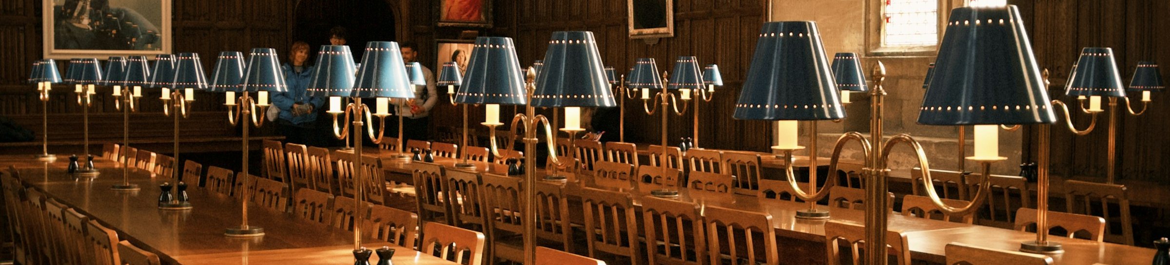 Reading room with long tables and brass lamps