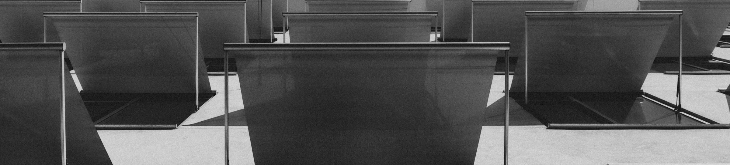 Rows of empty office desks in black and white